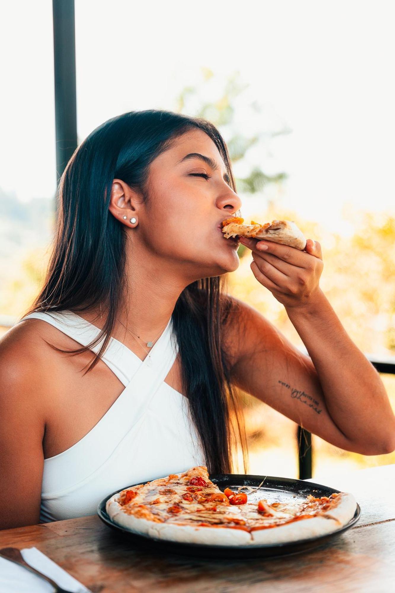 The Boato Hotel Guatape Luaran gambar A woman eating pizza